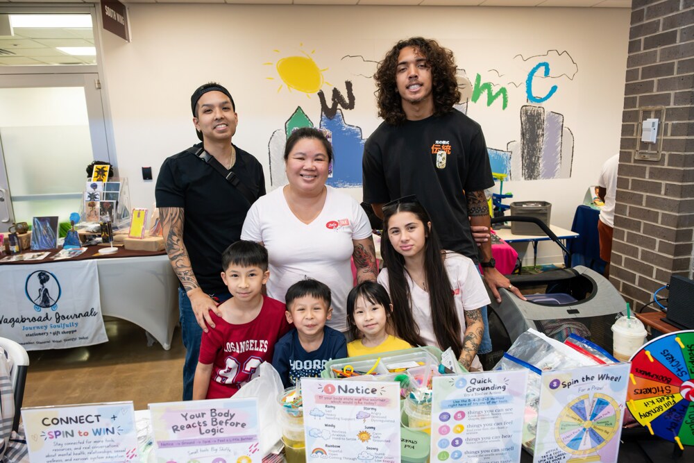 A family visiting a community resource table at Care Fest